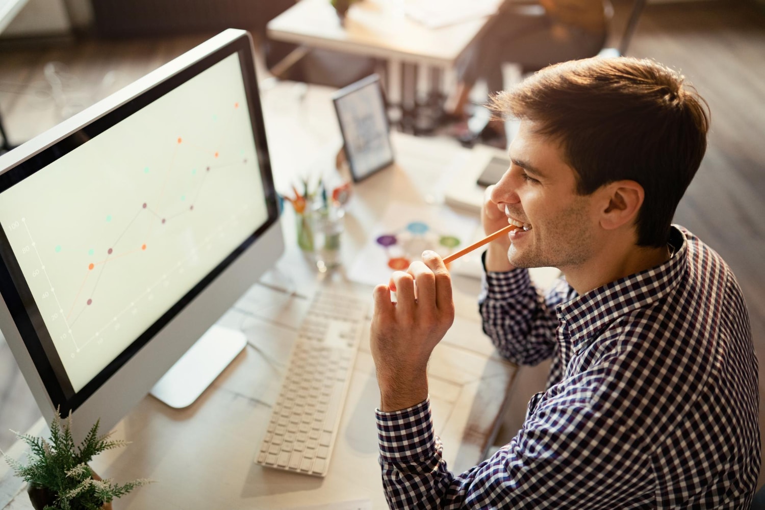 Homme consultant les performances de son site web sur un écran, illustrant les actions à mettre en place après une optimisation technique SEO.