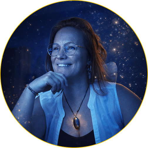 Portrait de la fondatrice de Stella Novum. Une femme rousse souriante avec des lunettes, la main sur le menton, dans une posture d'écoute réfléchie à son bureau.