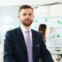 Portrait of businessman at office in presentable suit, colleagues discussing analytical data and statistics. Success, human resources, business, career growth concept